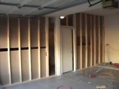 an unfinished room with wooden paneling and white walls