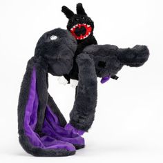 a stuffed animal that is wearing a purple and black scarf on it's back