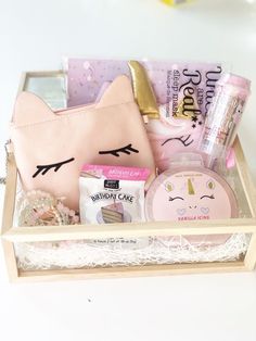 a pink purse with unicorn face on it and other items in the box next to it