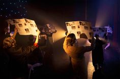 people holding up newspapers in the dark