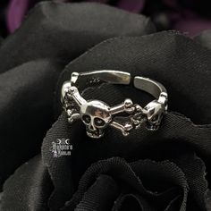 Embrace your Darker Side with this exquisite Skulls & Crossbones Adjustable Ring. Wear casual or dressy, whatever your heart desires. Enhance your Goddess look and pair with our Chokers, Necklaces, Bracelets, Rings, and Earrings. Details: 925 Sterling Silver Slightly Adjustable - fits sizes 7-9 best Width: 8mm Adjustable Gothic Stainless Steel Rings, Punk Style Metal Open Ring, Halloween Skull Jewelry In Bone Color, Halloween Skull Shaped Bone Jewelry, Gothic Skull Ring Metal Gift, Gothic Metal Skull Ring Gift, Adjustable Gothic Skull Jewelry, Halloween Hypoallergenic Metal Jewelry, Gothic Metal Skull Ring For Promise