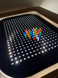 a group of colorful legos sitting on top of a black table with white dots