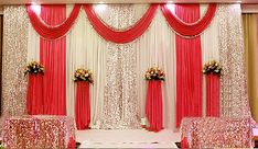 the wedding stage is decorated with red and white drapes