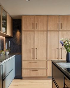 a kitchen with wooden cabinets and black counter tops