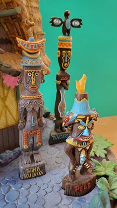 two wooden tiki figurines sitting on top of a table