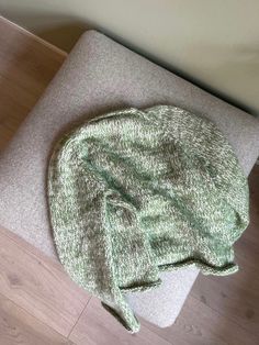 a green hat sitting on top of a wooden floor