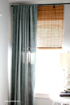 the curtains are pulled back in front of the window with blinds on both sides and one side open