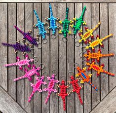 a group of cross stitch keychains in the shape of an airplane on a wooden surface