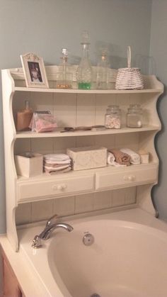 a bath tub sitting next to a white shelf