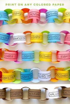 several different colored paper bracelets hanging on a wall with the words november printed on them