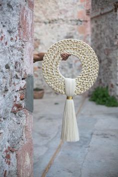 a white tassel hanging from the side of a brick building