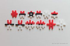 some type of bead art with black, white and red beads in the shape of sheeps