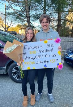 two people holding a sign that says flowers are the 2nd pretties thing can i go to prom with the 1st?