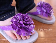 a close up of a person's feet wearing sandals with purple flowers on them