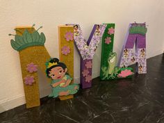 the letters are made out of paper and have princess characters on them