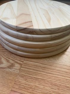 a stack of wooden plates sitting on top of a hard wood floor