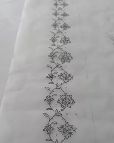 a long line of flowers is drawn on the side of a sheet of white paper