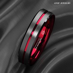 a red and black wedding ring with two stripes on the inside, sitting against a gray background