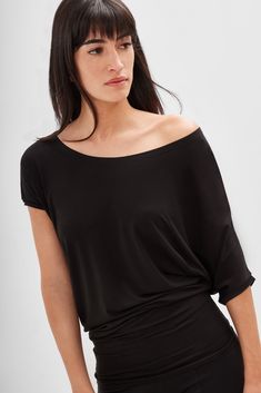 If you're in the mood to lounge luxuriously, our Elena Top is the move. Fashioned from our silky soft, eco-friendly European jersey, she features a loose scoop neck and asymmetric sleeves with a batwing on one side. The oversized fit tapers below the waist for a flattering fit. Elena's ideal for all-day wear, plus versatile enough for professional or casual looks. | Sam, in black, is 5'8" (173 cm) tall, wearing size XS. Natalee is 5'10" (178 cm) tall, wearing size M. Ariane, in light beige and i Minimalist Tops, Batwing Shirt, Minimalist Blouse, Scoop Neck Blouse, Minimalist Outfits, Minimalist Top, Boat Neck Blouse, Batwing Top, Night Tops