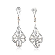 A pair of Edwardian-style dangling earrings centering two bezel-set transitional cut diamonds weighing approximately 0.12 carats each. The center stones are each surrounded by a floral design set with single cut diamonds. The total weight of the additional diamonds on each earring is approximately 0.47 carats. These earrings are platinum on 18k yellow gold.
These earrings are approximately 5.10cm in length.
If you have any questions about the Corringham earrings, please feel free to contact us. Antique Cushion Cut Diamond, Estate Diamond Jewelry, High Jewelry Ring, Edwardian Style, Cushion Cut Diamonds, Wedding Jewelry Earrings, Edwardian Fashion, Art Deco Diamond, Dangling Earrings