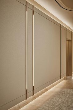 an empty hallway with white walls and beige carpeted flooring is lit by recess lights