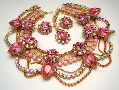 "Massive Showstopper Bib Necklace Earring Set Opalescent AB Pink Rhinestone Glass Marked Show Must Go On. Marked on All Three Pieces \"Show Must Go On\". The Necklace is Approximately 20\" Long and 3\" Wide. Earrings are Clip Backed and Measure 1 3/8\" Diameter. Condition is Excellent with No Flaws and Minimal Wear or Aging...appears never worn. I will be listing another pair of earrings that match this set separately if you prefer dangle earrings." Multicolor Metal Rhinestone Necklace For Party, Elegant Multicolor Rhinestone Necklaces, Multicolor Crystal Necklace With Rhinestones, Adjustable Multicolor Bib Necklace, Multicolor Rhinestone Necklace With Jewels, Costume Jewelry, Rhinestone Brooches, Pink Rhinestones, Bib Necklace, Necklace Earring Set