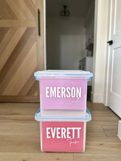 two plastic containers with the words emerson and everett on them sitting in front of a door