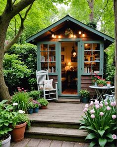 a small wooden shed sitting in the middle of a lush green forest filled with flowers