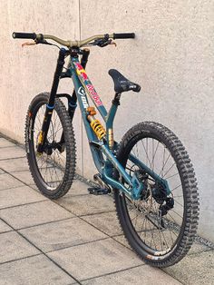 a blue and black bike parked on the side of a building next to a wall