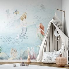 a child's room decorated in pastel colors with mermaids and fish wallpaper