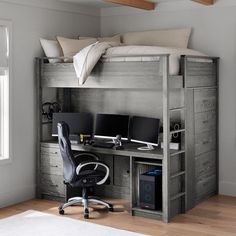 a loft bed with a desk and computer on it in a room that has hardwood floors