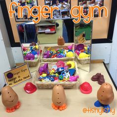 there are many toys on the table in front of the mirror that says finger gym