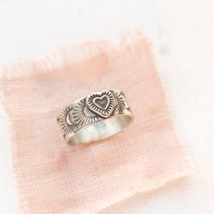 As sweet as could be. A little intricate heart is set on a stamped silver band. Versatile enough to stack with others or wear alone. 7.5 mm wide. Choose your ring size during checkout. Because this is a band ring, we recommend ordering a 1/2 size larger. The design is hand stamped, so slight variations will occur. Sterling silver. Your jewelry will arrive beautifully gift wrapped in a small box. Multiple items will be combined, unless separate boxes are requested. If this is a gift being shipped directly to the recipient, please let me know. I will be glad to include a note from you. Your jewelry will arrive beautifully gift wrapped in a small box. Multiple items will be combined, unless separate boxes are requested. If this is a gift being shipped directly to the recipient, please let me Adjustable Engraved Heart Ring, Sterling Silver Heirloom Heart Ring For Promise, Heirloom Sterling Silver Heart Ring For Promise, Bohemian Engraved Ring Stamped 925 For Anniversary, Bohemian Sterling Silver Engraved Ring For Anniversary, Bohemian Handmade Heart Ring Gift, Handmade Bohemian Heart Ring Gift, Sterling Silver Heart-shaped Engraved Promise Ring, Heart-shaped Sterling Silver Engraved Promise Ring