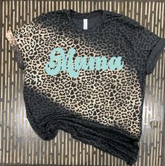 a t - shirt that is laying on top of a bamboo mat with a black and white animal print