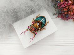 a beaded brooch sitting on top of a white napkin