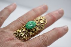 "Beautiful Ornate Filigree flower pattern is a very eye catching statement ring. Measures: 2 1/4\" long- 7/8\" Wide- 1 1/4\" Height Green Stone Measures: 20mm x 12mm Weight; 9.5g The ring is ornate filigree in a bronze metal." Vintage Rings For Spring Gift, Vintage Adjustable Flower Ring For Spring, Adjustable Vintage Flower Ring For Spring, Gold Vintage Jewelry For Spring, Vintage Flower Ring For Spring Gift, Spring Vintage Gold Jewelry, Vintage Green Flower Ring, Vintage Spring Wedding Jewelry, Vintage Onyx Ring