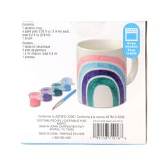 the package contains an assortment of paints and a mug with a rainbow painted on it