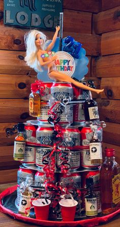 a cake made to look like a birthday cake with a barbie doll on top and lots of liquor