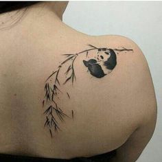 the back of a woman's shoulder with a panda tattoo on it