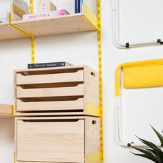 a wooden box sitting on top of a shelf next to a plant