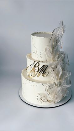 a three tiered wedding cake with white frosting