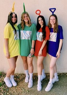 three girls are standing in front of a wall and one girl is wearing a costume