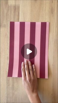 someone is cutting out pink and purple paper with a video playing on the bottom right corner