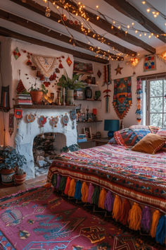 a bedroom with a large bed covered in colorful blankets and pillows next to a fire place