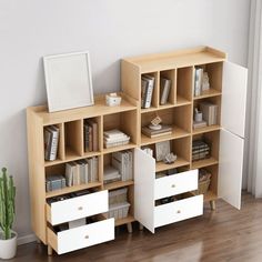 a bookshelf with several drawers and a mirror on it next to a potted cactus