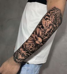 a man's arm with an eagle and skull tattoo on it