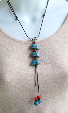 "Adjustable long necklace, made with blue and red ceramic beads. The cord is black color. Easy to match any style of tops or dresses. Versatile and eye catching accessory. Material is ceramic, metal and cord The length is adjustable ( approx. 17\" inches long ) ( Ceramic: Inorganic powder that is molded under pressure and fire at high temperature)" Blue Bohemian Long Necklace With Colorful Beads, Adjustable Large Beads Hippie Necklace, Blue Beaded Bohemian Long Necklace, Blue Hand-strung Bohemian Beaded Necklaces, Bohemian Blue Hand-strung Beaded Necklaces, Choker, Ceramic Beads, Boho Necklace, Long Necklace