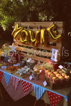 a table topped with lots of food next to a wooden sign that says i love