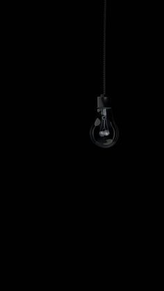 a light bulb hanging from a black ceiling