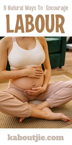 a pregnant woman is sitting on the floor with her hands in her stomach while holding her belly